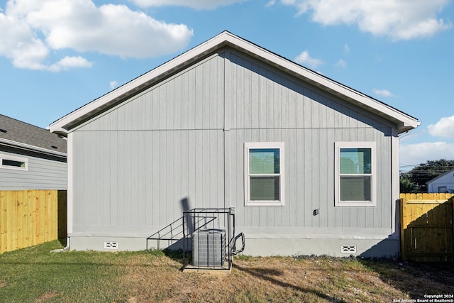 back of property featuring central AC and a yard