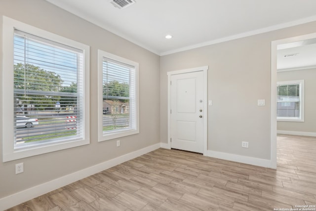 spare room featuring light hardwood / wood-style floors and crown molding