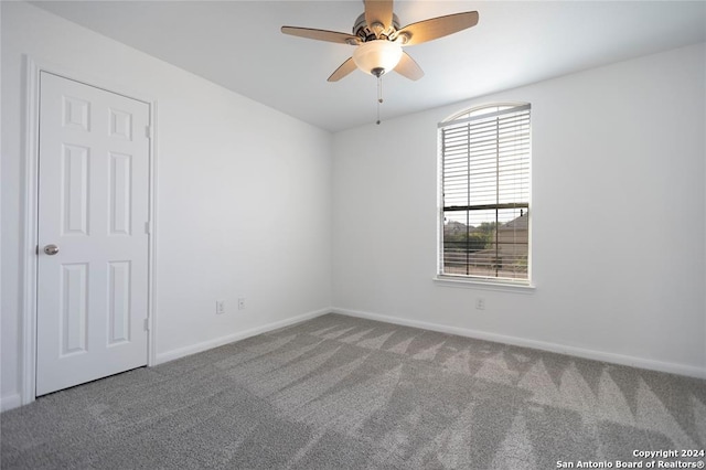 carpeted spare room with ceiling fan