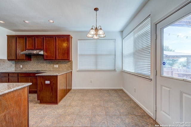 kitchen featuring decorative backsplash, black electric stovetop, light tile patterned floors, decorative light fixtures, and a notable chandelier