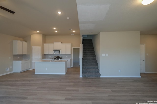 6727 Tasajillo Spg, San Antonio, TX 78253 - kitchen with stainless steel microwave, open floor plan, white cabinets, backsplash, and recessed lighting