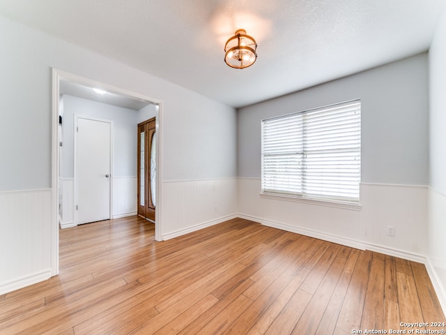 empty room featuring light wood-type flooring and a textured ceiling