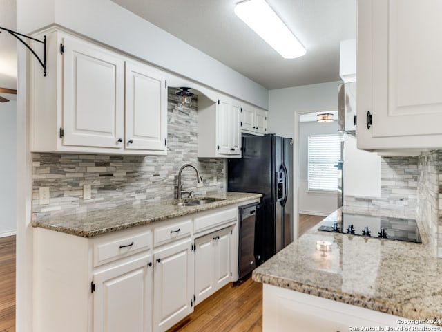 kitchen with white cabinets, decorative backsplash, light hardwood / wood-style floors, and sink