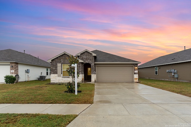 ranch-style home featuring cooling unit, a garage, and a yard