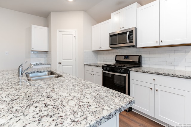 kitchen featuring decorative backsplash, appliances with stainless steel finishes, white cabinets, and sink