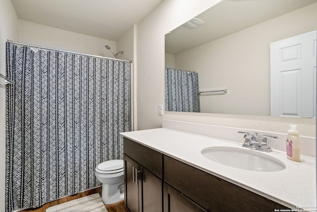 bathroom with a shower with curtain, vanity, hardwood / wood-style flooring, and toilet