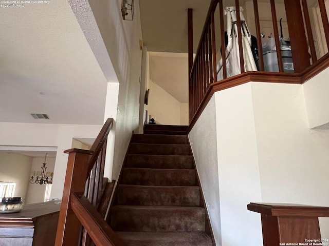 stairs featuring an inviting chandelier