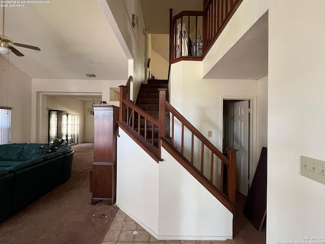 stairs featuring tile patterned flooring and ceiling fan