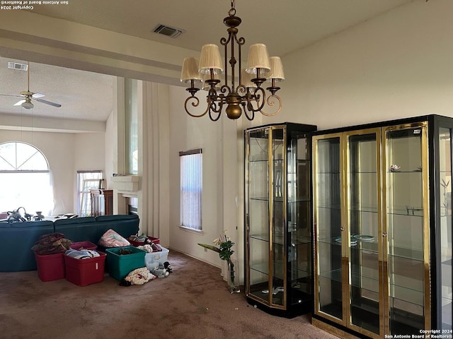 interior space with ceiling fan with notable chandelier, a textured ceiling, carpet floors, and lofted ceiling