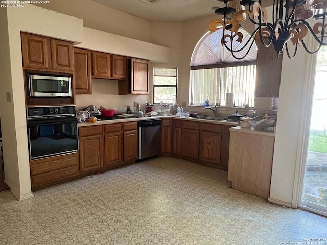 kitchen featuring appliances with stainless steel finishes, an inviting chandelier, and sink