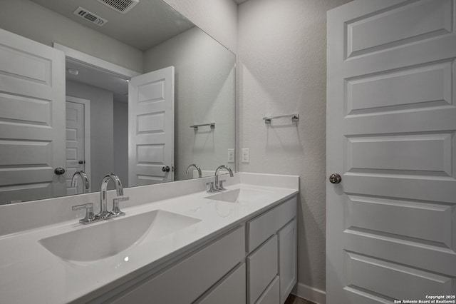 4750 Sahara Vlys, San Antonio, TX 78222 - bathroom with double vanity and a textured wall