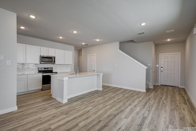 4750 Sahara Vlys, San Antonio, TX 78222 - kitchen with appliances with stainless steel finishes, a sink, light wood-type flooring, white cabinets, and recessed lighting