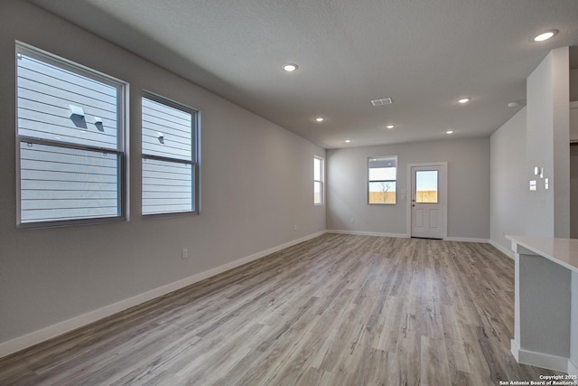 4750 Sahara Vlys, San Antonio, TX 78222 - empty room featuring light wood finished floors, baseboards, recessed lighting, and a textured ceiling