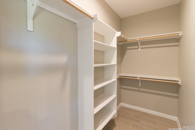 walk in closet with hardwood / wood-style flooring