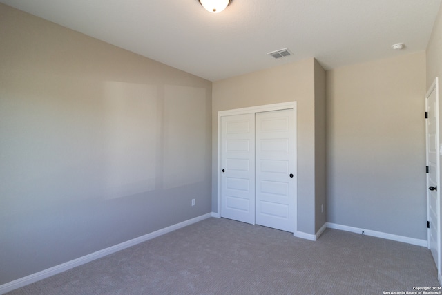 unfurnished bedroom featuring dark carpet and a closet