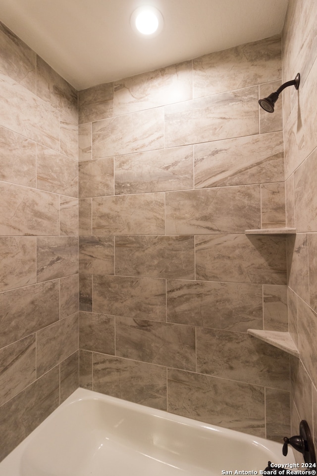 bathroom with tiled shower / bath combo