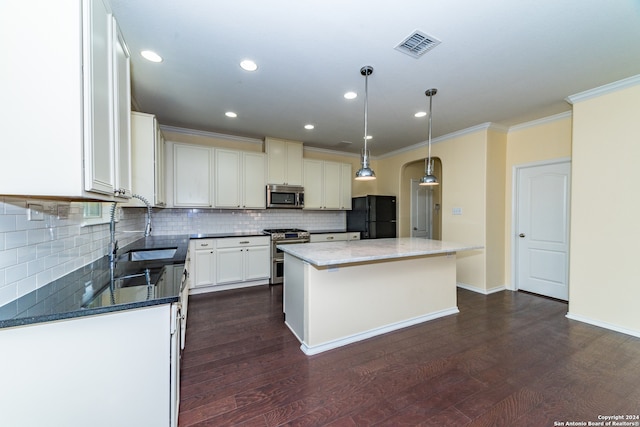 kitchen with stainless steel appliances, sink, white cabinetry, dark hardwood / wood-style floors, and a kitchen island