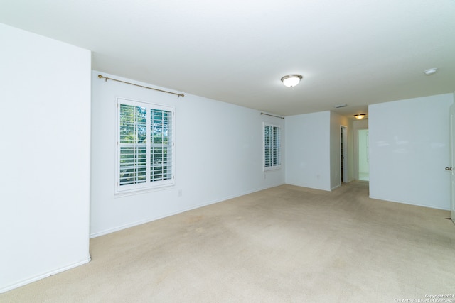 spare room featuring light carpet