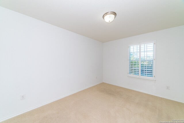 spare room featuring light colored carpet