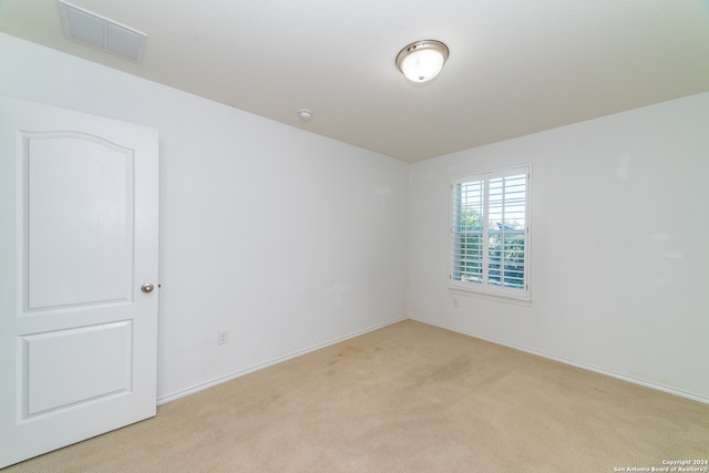 spare room featuring light colored carpet