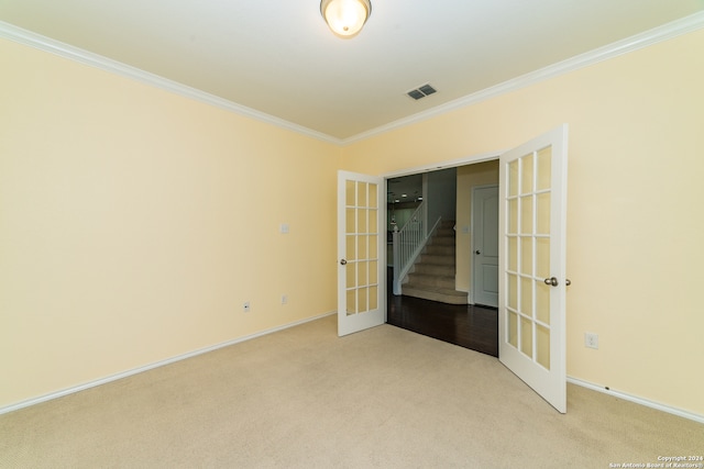 carpeted empty room featuring ornamental molding and french doors