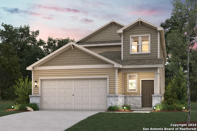 craftsman inspired home featuring a garage and a lawn