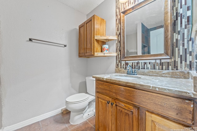 bathroom featuring tile patterned flooring, vanity, a textured ceiling, and toilet