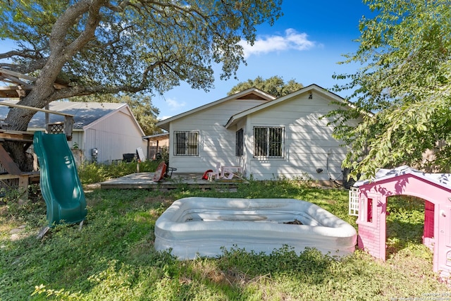 back of property featuring a playground