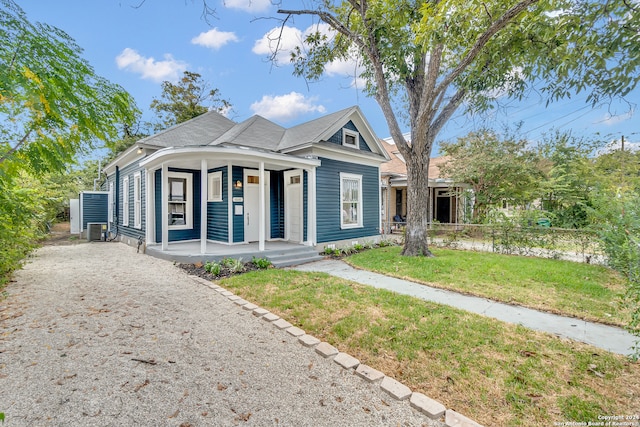 bungalow-style home featuring covered porch, central AC, and a front yard