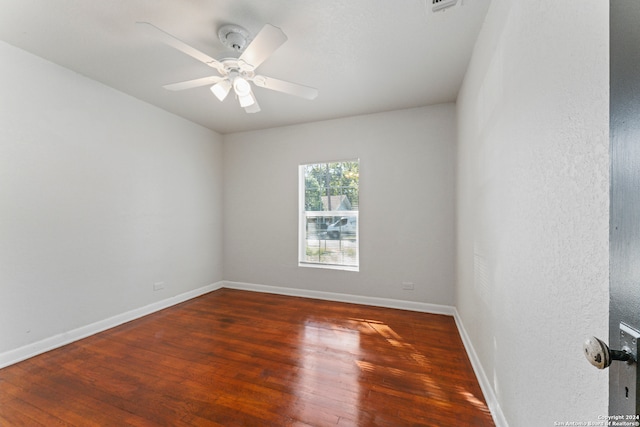 empty room featuring ceiling fan and dark hardwood / wood-style flooring