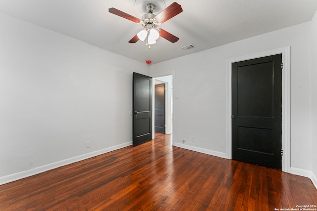 spare room featuring ceiling fan and dark wood-type flooring