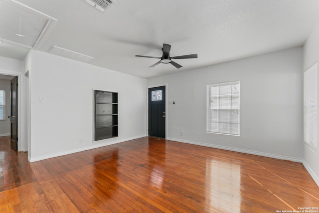 empty room featuring hardwood / wood-style flooring, ceiling fan, and a textured ceiling