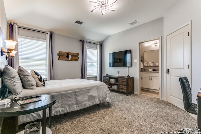 bedroom with connected bathroom, carpet floors, and lofted ceiling