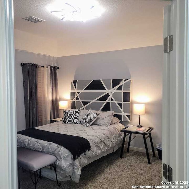 bedroom featuring carpet and a textured ceiling