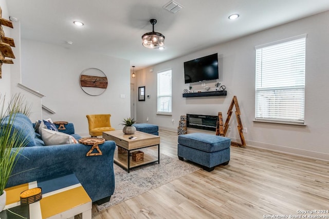 7544 Magnolia Vlg, San Antonio, TX 78252 - living room featuring wood finished floors, a glass covered fireplace, baseboards, and recessed lighting