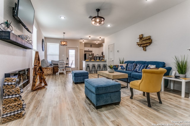 living room featuring a chandelier and light wood-type flooring