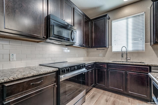 11902 Silver Horse, San Antonio, TX 78254 - kitchen featuring black appliances, a sink, light stone countertops, light wood-style floors, and backsplash