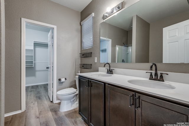 bathroom featuring toilet, vanity, wood-type flooring, and walk in shower