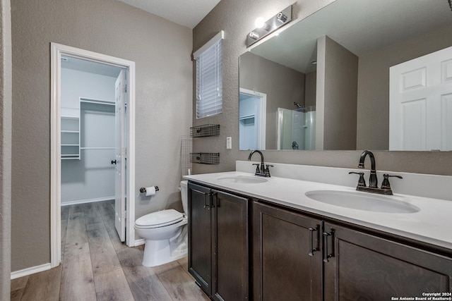 11902 Silver Horse, San Antonio, TX 78254 - full bath featuring wood finished floors, a textured wall, double vanity, a spacious closet, and a shower