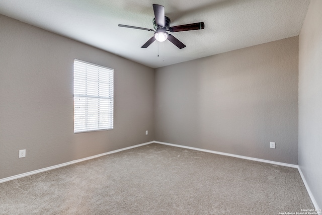 carpeted spare room featuring ceiling fan and a textured ceiling