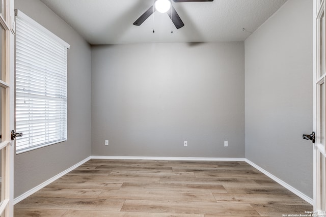 unfurnished room with ceiling fan, french doors, light hardwood / wood-style floors, and a textured ceiling