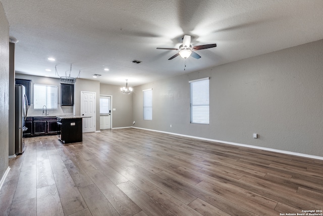 kitchen with stainless steel refrigerator, sink, a kitchen island, and hardwood / wood-style flooring