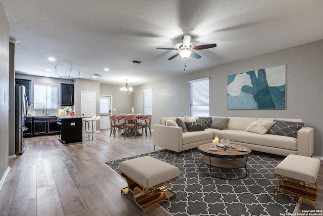11902 Silver Horse, San Antonio, TX 78254 - living area featuring a chandelier, light wood-style floors, a ceiling fan, a textured ceiling, and recessed lighting