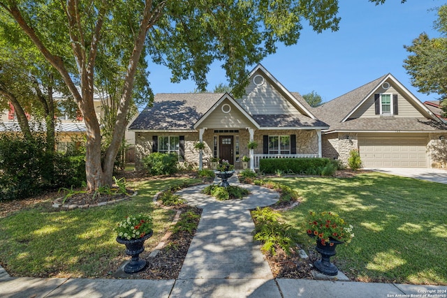 craftsman-style house with covered porch, a garage, and a front yard