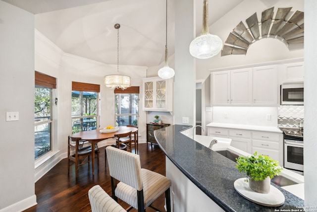 kitchen with white cabinets, appliances with stainless steel finishes, decorative light fixtures, and sink