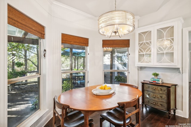 dining room featuring crown molding, plenty of natural light, dark wood-type flooring, and a notable chandelier