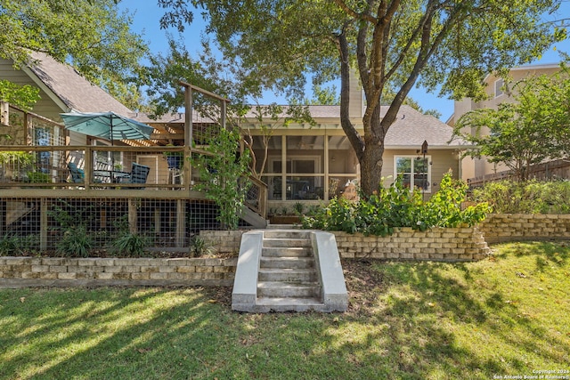 back of house with a lawn, a wooden deck, and a sunroom