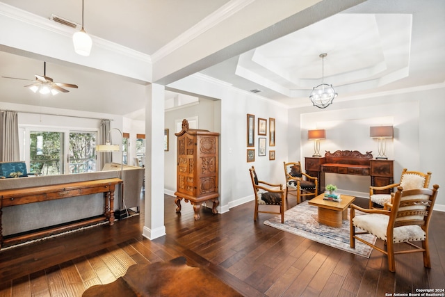 living room featuring dark hardwood / wood-style floors, a tray ceiling, and crown molding