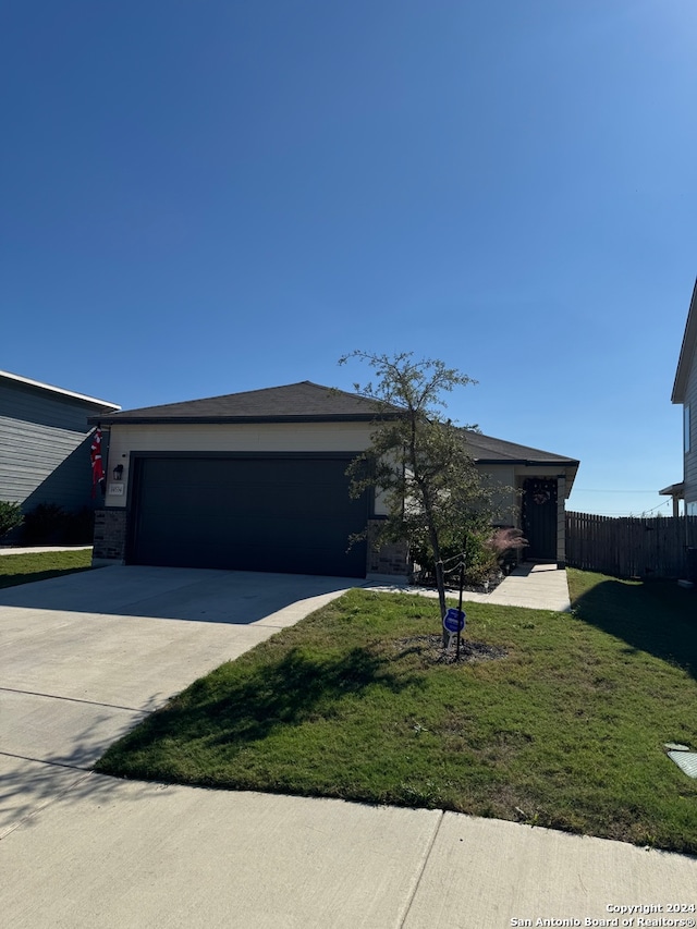 single story home featuring a front yard and a garage