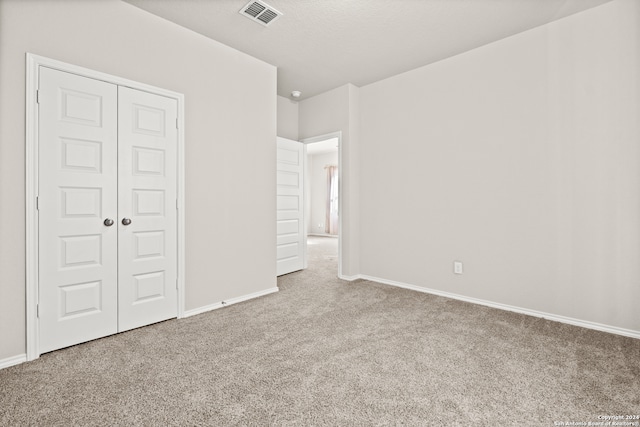 unfurnished bedroom featuring carpet flooring and a closet